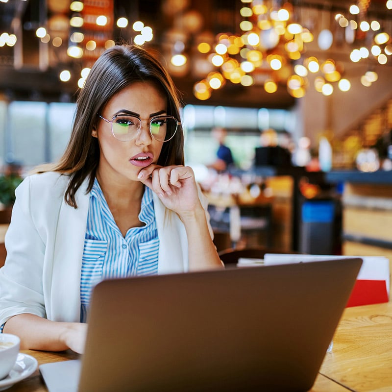 Picture of an employee working remote in a cafe and accessing SaaS apps securely with the power of Microsoft Entra 