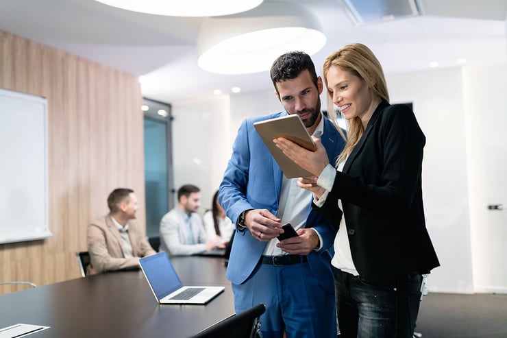 Picture of employees in a meeting room taking a look at the training programs offered on cybersecurity best practices that can help prevent human error-related incidents like phishing attacks.