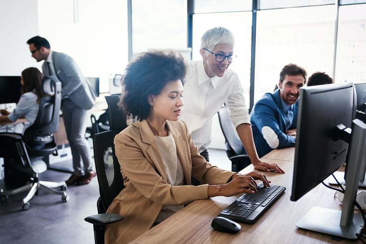 Picture of employee with team manager looking into the various comprehensive training programs offered to users to learn Microsoft 365 and other cloud services.