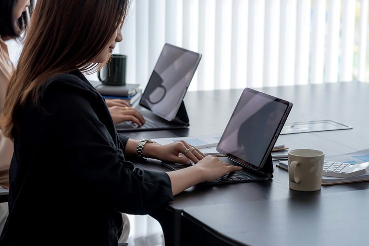 Employees from the marketing team at an engineering firm work productively on their Microsoft Surface laptops, seamlessly accessing Microsoft 365 applications and collaborating in real time, all made possible through their organization’s partnership with a Microsoft CSP.