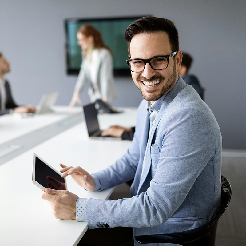 A man uses a tablet during a quarterly business report meeting to access sensitive workload applications and work with streamlined efficiency in his organization.