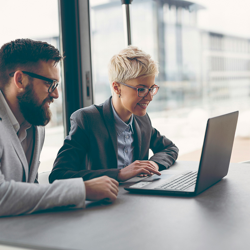 Employees collaborating on a project through a laptop that accesses the organization's private applications safely and securely using Entra Private Access.