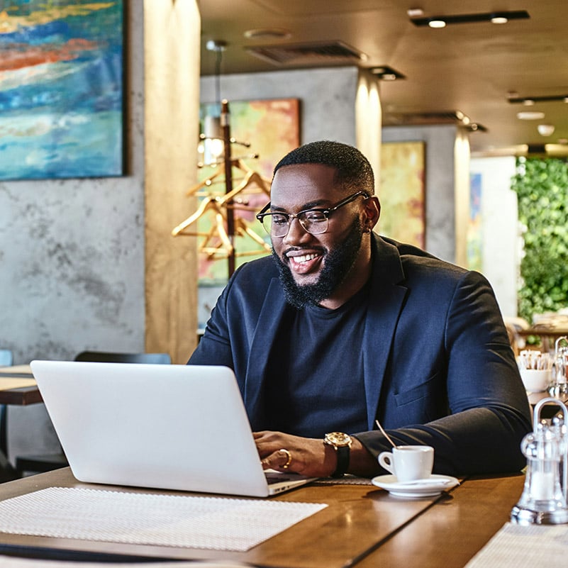 An employee working from a satellite office verifies his identity through Entra Verified ID to access resources and apps.