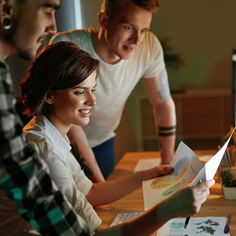 Employees in a finance firm analyzing charts on a graph through resources they've been given access using Entra Verified ID.